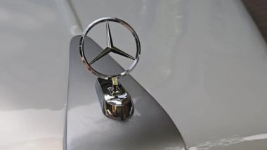 Klasik bir eski arabanın beyaz kaputuna Mercedes-Benz logosu monte edilmiş. Tiflis, Gürcistan - 26 Mayıs 2025.