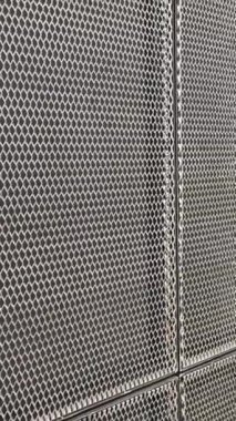 Metal ağ duvar panellerine yansıyan ışık modern bir mimari tasarım yaratıyor.