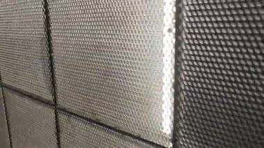 Genişletilmiş bir metal ağ duvarının yakın görüntüsü, dokusu ve modern mimari tasarımı vurgulanıyor