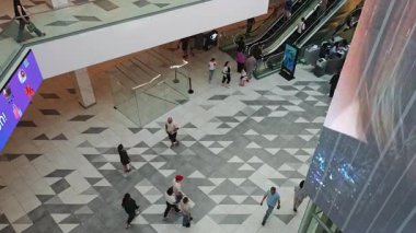 Modern alışveriş merkezlerinde büyük dijital işaretlerle yürüyen müşteriler. Tiflis, Gürcistan - 8 Haziran 2025.