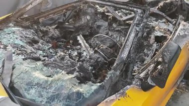 Üstü açılabilir bir arabayı yutan yangından sonra çekilen yakın çekim geniş çaplı hasar yaratıyor.