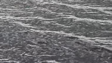 Karanlık su yüzeyi yumuşak, dalgalı dalgalanmalar yaratıyor. Yumuşak, büyüleyici desenler sakin enerji ve akışkan hareketi yansıtıyor.