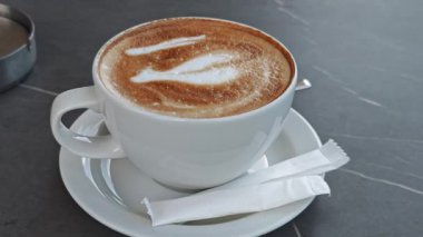 Profesyonel baristaları gösteren kremalı kapuçino. Karmaşık latte sanat desenleri. Kahverengi ve beyaz zıt köpük dokusuyla hassas tasarımı ortaya çıkarıyor.