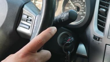 Arabadaki silecekleri çalıştıran bir adamın el çekimi.