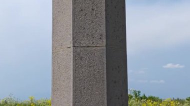 Mavi gökyüzünün altında hayvan figürleri, ağaçlar ve geometrik süslemelerle granit dikili detaylar