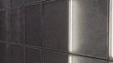 Metal ağ panelleri ve entegre aydınlatma birleşimi binanın içinde modern ve şık bir atmosfer yaratıyor.