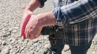 Tripoda monte edilmiş kamerayla odaklanan fotoğrafçı