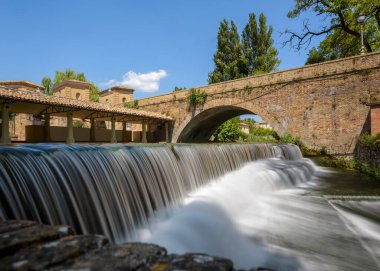 Nehrin güzel manzarası ve Bevagna, Umbria, İtalya 'nın tarihi merkezindeki küçük köprüsü..