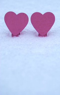 Aşkın sembolleri. Soğuk kar üzerinde iki parlak kalp.