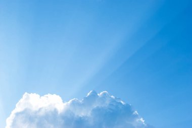 Kabarık bir buluttan gelen güneş ışınları