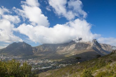 Açık bir günde Masa Dağı 'nın üzerinden bulutlar dökülüyor, Cape Town, Güney Afrika
