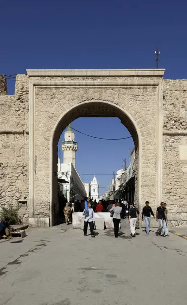 2009年11月4日 利比亚的黎波里 的黎波里的古城 Medina 的入口 清真寺的塔楼在后面清晰可见 在前景中可以看到一个街头摊贩 — 图库照片