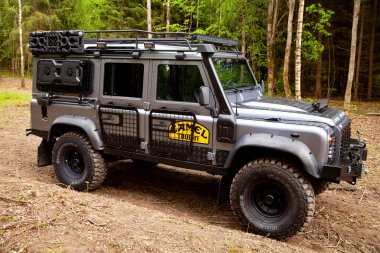 Equipped Land Rover Defender in the forest, ready for off road clipart