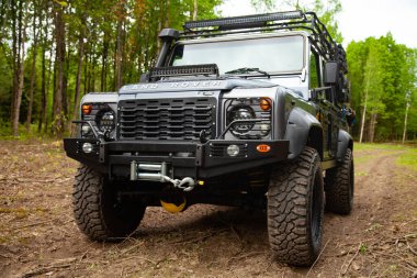 Equipped Land Rover Defender in the forest, ready for off road clipart