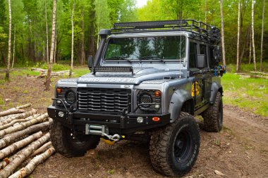 Ormandaki donanımlı Land Rover Koruyucusu, off road için hazır, yeteneklerini gösteriyor.
