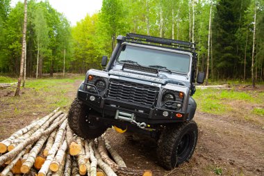 Ormandaki donanımlı Land Rover Koruyucusu, off road için hazır, yeteneklerini gösteriyor.