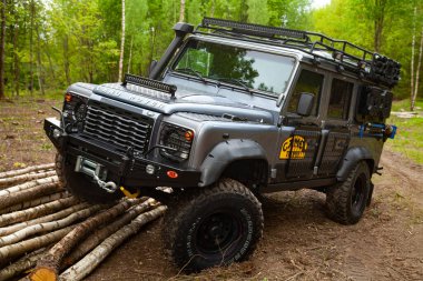 Ormandaki donanımlı Land Rover Koruyucusu, off road için hazır, yeteneklerini gösteriyor.