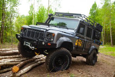 Ormandaki donanımlı Land Rover Koruyucusu, off road için hazır, yeteneklerini gösteriyor.