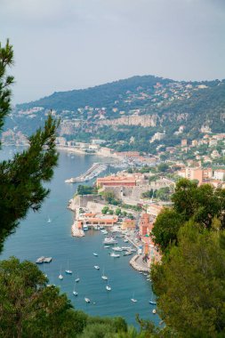 Bir güney şehri bir dağ ve tekneli bir liman ile çevrilidir.