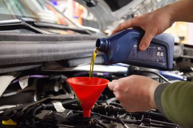 Vilnius, Litvanya - 21.12.2024 - Otomobil tamircisi yeni motor BMW yağ dolduruyor