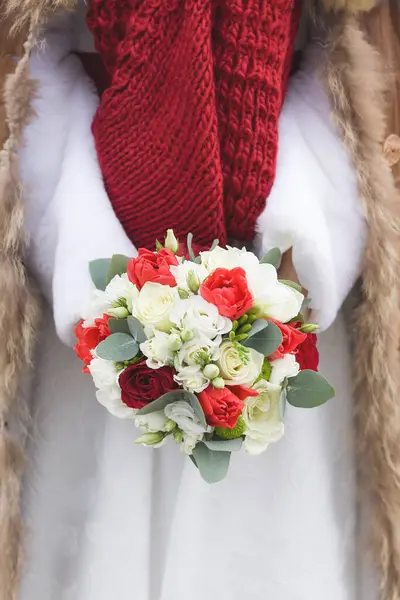 Karlı bir günde gelinin elinde kış düğün buketi