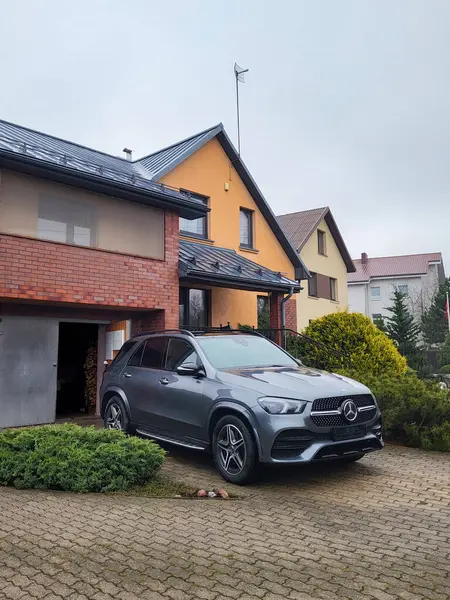 Vilnius, Litvanya - 2025-01-29 - Özel bir evin avlusunda dizel elektrikli Mercedes GLE, büyük bir aile için rahat bir yolculuğa hazır.