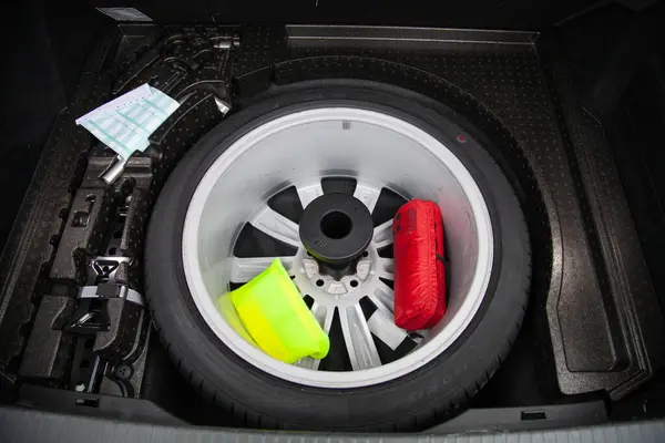 Yedek lastik, yansıtıcı yelek, ilk yardım çantası ve arabanın bagajında yer altındaki acil durum işareti.