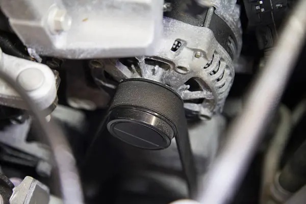 Motor kayışının yakın çekimi arabanın kaputunun altındaki retraktör makarasında gerilmeye başladı.