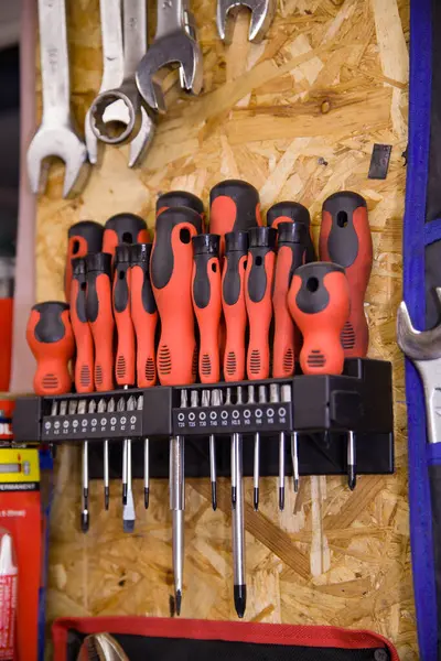 Kırmızı lastik saplı çeşitli tornavidalar duvarda asılı duruyor..