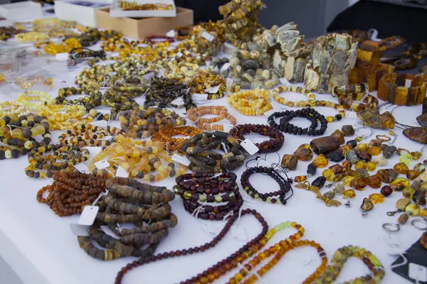 Çeşitli gölgelerde kehribardan yapılmış hatıra ve mücevherler, şehir panayırındaki bir marketin tezgahında sergileniyor.