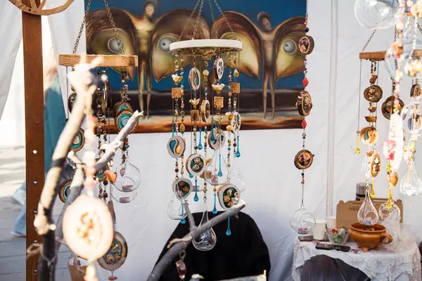 Vilnius, Litvanya - 08-03-2025 - Kaziukas Fuarı 'nda kurutulmuş çiçekler ve doğal taşlarla süslenmiş rüzgar çanları gibi ahşap ve camdan yapılmış eşsiz ve rafine asılı süsler