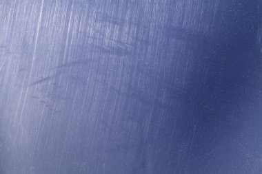 Parlak mavi plastik yüzey, görünür çizikler ve toz parçacıkları, güneş ışığıyla aydınlatılıyor. Yüksek detaylı desenli arkaplan