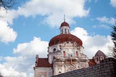 Vilnius, Litvanya - 17-03-2017 - Kırık alçı ve yıpranmış cepheli eski bir Katolik katedrali, açık mavi gökyüzüne karşı şehir merkezinde duruyor. Tarihsel Avrupa mimarisi