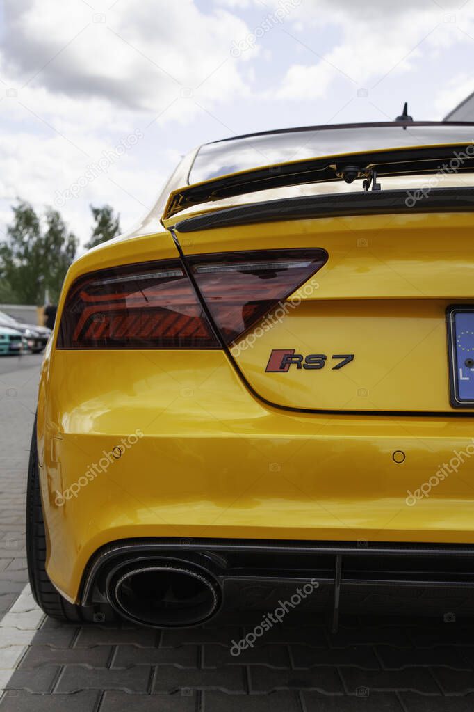 Vilnius, Lithuania - 31-05-2025 - Back view of a mustard-colored Audi RS7 sports car parked outdoors