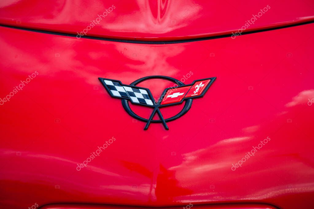 Vilnius, Lithuania - 31-05-2025 - Chevrolet Corvette logo on a bright red car hood, close-up. Sport car emblem detail