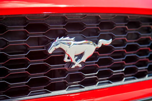 Vilnius, Litvanya - 31-05-2025 - Kırmızı bir arabanın ön ızgarasında gümüş at şeklinde Ford Mustang logosu
