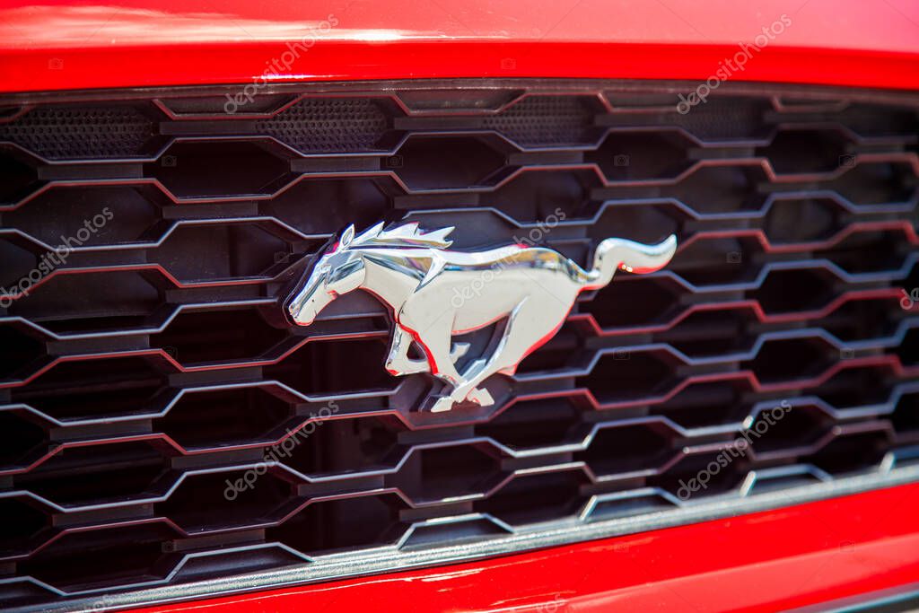 Vilnius, Lithuania - 31-05-2025 - Ford Mustang logo in the shape of a silver horse on the front grille of a red car