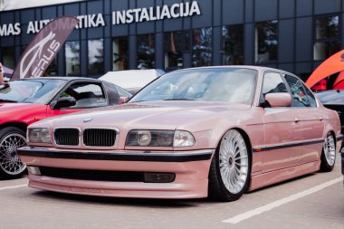 Vilnius, Lithuania - 31-05-2025 - Lowered BMW 7 E38 in a gentle peach shade, captured at a car meet on a parking lot