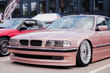 Vilnius, Lithuania - 31-05-2025 - Lowered BMW 7 E38 in a gentle peach shade, captured at a car meet on a parking lot