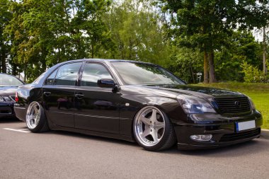 Vilnius, Litvanya - 31-05-2025 - Siyah bir Lexus LS430 UCF30 'un ön ucu negatif camberli ve cilalı derin-tabak tekerlekleri, düşük duruş ve şehir parkında özel detay