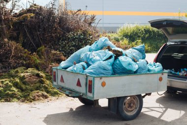 Geri dönüşüm sahnesi: gübre için yaprak ve çimen dolu eski bir araç römorku