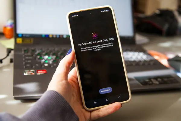 Vilnius, Lithuania - 2025-09-26 - Smartphone in hand with remind notification to close Instagram app. Instagram time limit to combat to stop procrastination