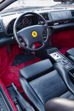 Vilnius, Lithuania - 2025-09-20 - Classic Ferrari interior with red velvet and black leather, view of driver seat and dashboard