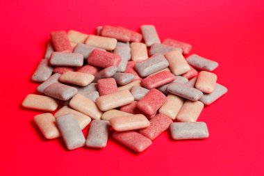 Pembe arka planda renkli sakız parçaları.