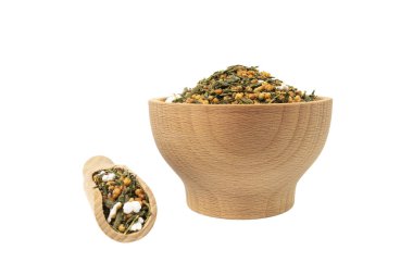 Yeşil çay Japon Genmaicha. Kavrulmuş yeşil çay ahşap kasede patlamış kahverengi pirinç ve beyaz arka planda izole edilmiş kepçe..