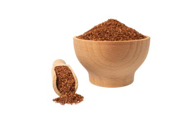 Rooibos tea medium cut in wooden bowl and scoop isolated on white background. Rooibos in latin Aspalathus linearis. herb. herbal tea. food ingredient.