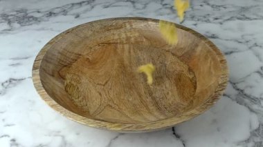 Mafaldine Corte makarnası ahşap kaseye düşüyor. Mermer çalışma arkaplanı.