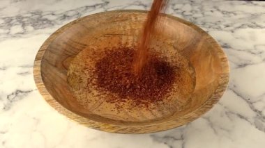 Rooibos çayı, tahta tabağa düşerken kesilmiş. yavaş çekim.