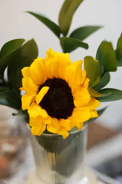 a bouquet of yellow sunflowers in a vase on the table.