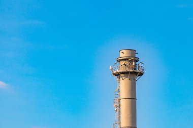 Mavi gökyüzü arkaplanlı petrol rafinerisinde gaz patlamaları